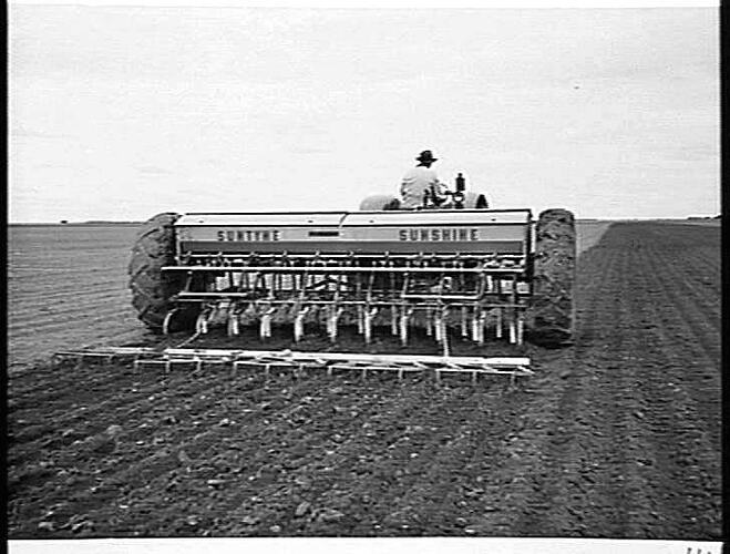 BROAD ACRES. A TYPICAL SCENE AT SEEDING TIME IN THE WIMMERA. MR. R. GIDDINGS, BLACKHEATH VIA HORSHAM, WITH HIS SUNSHINE MASSEY HARRIS 55K TRACTOR, 500-SERIES `SUNTYNE' CULTIVATING DRILL AND `SUNTOW' STUMP-JUMP HARROWS: JUNE 1952