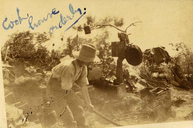 Man cooking at camp fire.