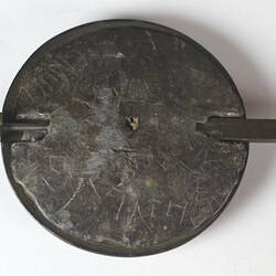 Detail of round weight, rear view.