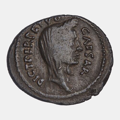 Irregular round coin. Wreathed head of man facing right wearing veil. text around.