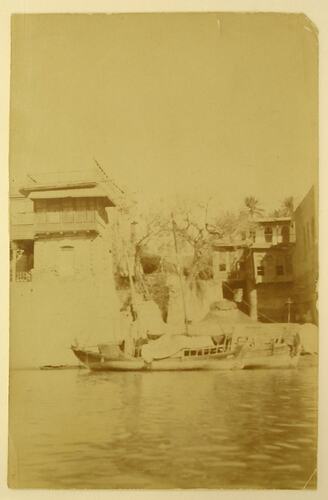 Boats and buildings on the river front, seen from water.