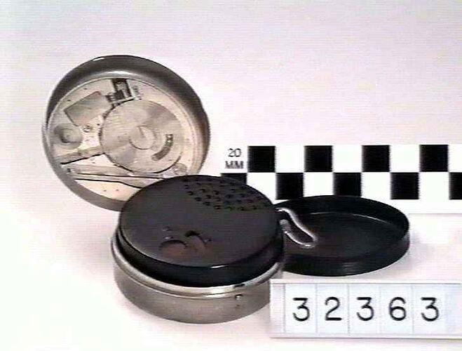 Pocket phonograph case with lid open showing contents.
