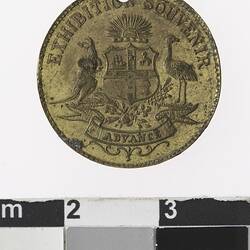 Round gold coloured medal with Australian coat of arms and text.