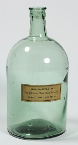 Glass bottle with paper label.