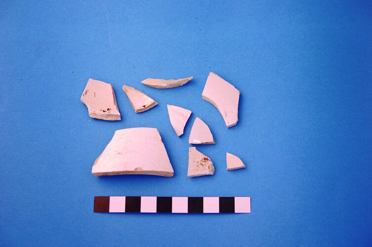 Nine fragments of white glazed earthenware.