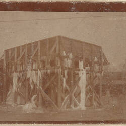Open wooden construction with large icicles hanging from building.