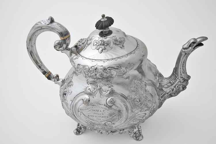 Ornate silver teapot with lid. Right profile.