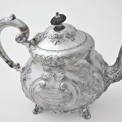 Ornate silver teapot with lid. Right profile.