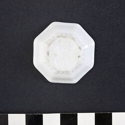 Underside of dolls size white ceramic octagonal plate.
