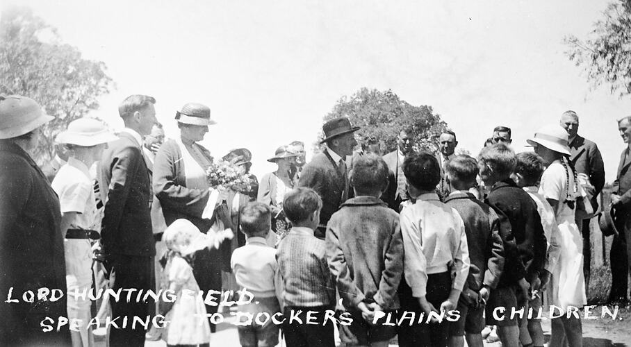 Man speaking with group of children.