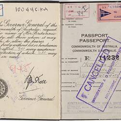 Open passport with white pages. Black printed text and handwriting. Purple Cancelled stamp.