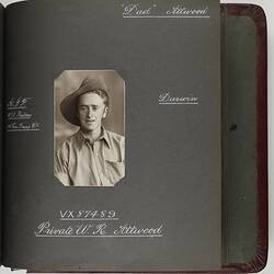 Page with handwritten white text and photograph of servicemen in centre.