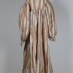 Back view, long dress, cream and tan stripes.