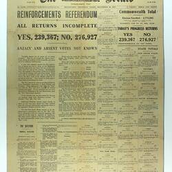 Newspaper page with black printed text on yellow paper.