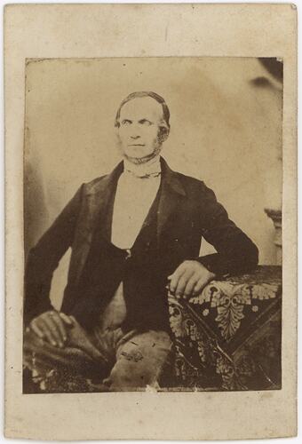 Seated man in formal attire.