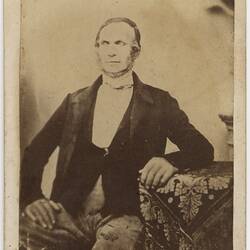 Seated man in formal attire.