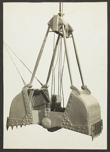 Monochrome photograph of an excavator bucket.