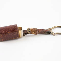Miniature mouth organ in a leather case.