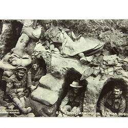 Front of postcard with soldiers in dugouts.