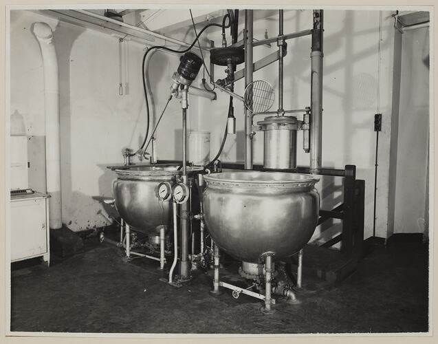 Industrial interior, dominated by two large round vats.