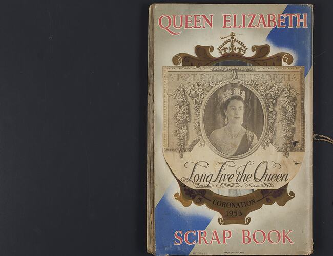 Back cover of scrapbook, black and white image of Queen Elizabeth II pasted over central oval medallion.