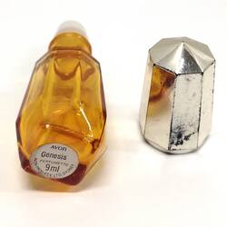 Yellow glass perfume bottle underside, labelled, next to lid.