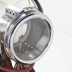 Red motor cycle, headlight with silver frame detail.
