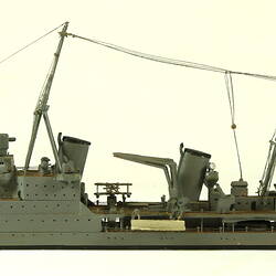 Naval ship with two masts, facing left.