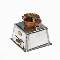 Miniature coffee grinder made from silver and copper. Brass handle on top, silver box base has drawer.