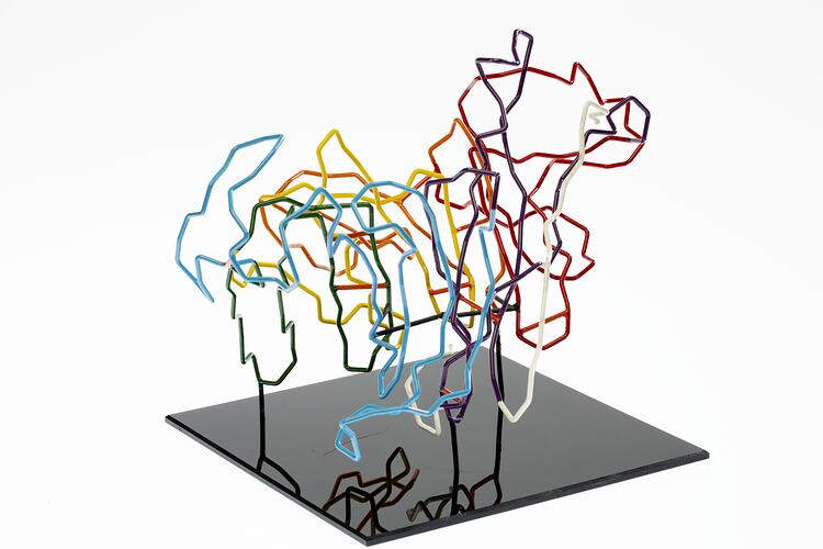 Red, orange, yellow, green, blue, purple and white coloured wires mounted on a black wooden base.
