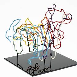 Red, orange, yellow, green, blue, purple and white coloured wires mounted on a black wooden base.