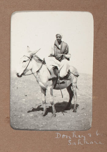 Man seated on donkey.