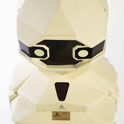 Cream plastic robot with angular human-like shape, ie. head, shoulders, waist and legs. Black plastic features.