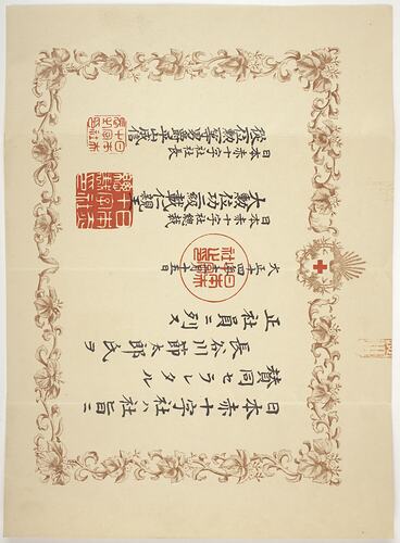 Cream sheet with printed brown floral border, black printed Japanese text with three red stamps.