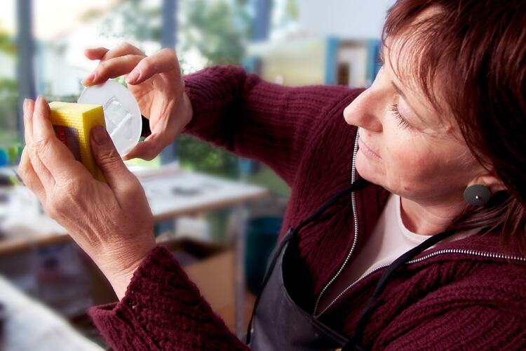 Woman polishing a section of glass.