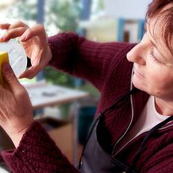 Woman polishing a section of glass.