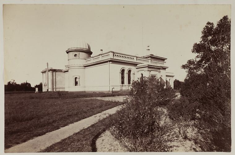 View looking up path with dardens eiter side towards a prominent domed buidling.