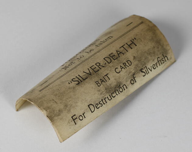 Discoloured curled bait card with printed black text.