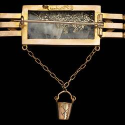 Reverse view of triple bar brooch with central quartz and gold specimen with small gold bucket attached.