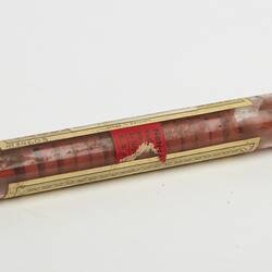 Glass tube, metal lid. Contains red tablets. Paper labels with text affixed to tube.