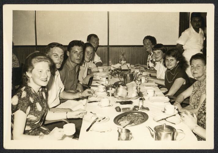 Group seated at dining table posing for photograph.