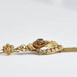 Gold and green pendant earring with fringing. Profile.