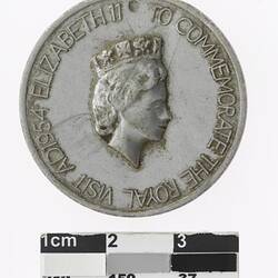 Round silver medal with profile of a crowned woman and text surrounding.