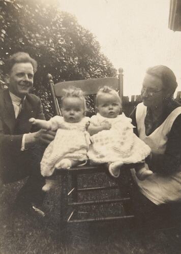 Digital Photograph - Twin Baby Girls in Chair, with Father & Grandmother, St Kilda, 1942