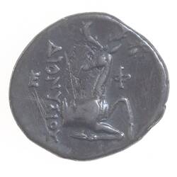 Irregular round silver coin with text beside a seated stag.
