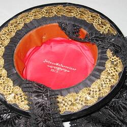 Underside of hat with black and gold lace