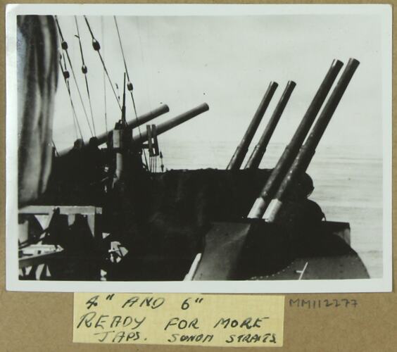 Three sets of canons on a naval ship pointing out to sea.