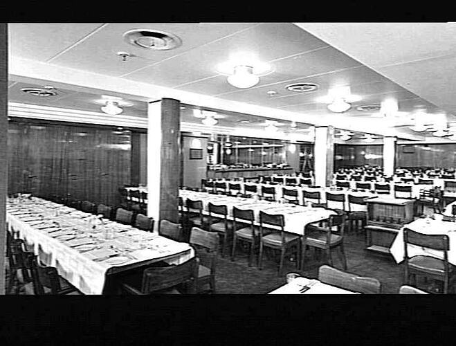 Ship interior. Dining area with mulitple long tables set.