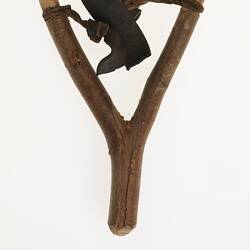 Wooden and leather slingshot, back view.