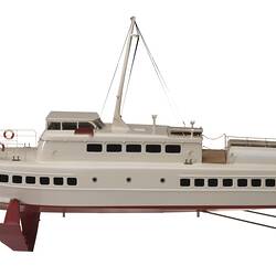 White metal hydrofoil model with red hull and skis and white deck. Mast on top.